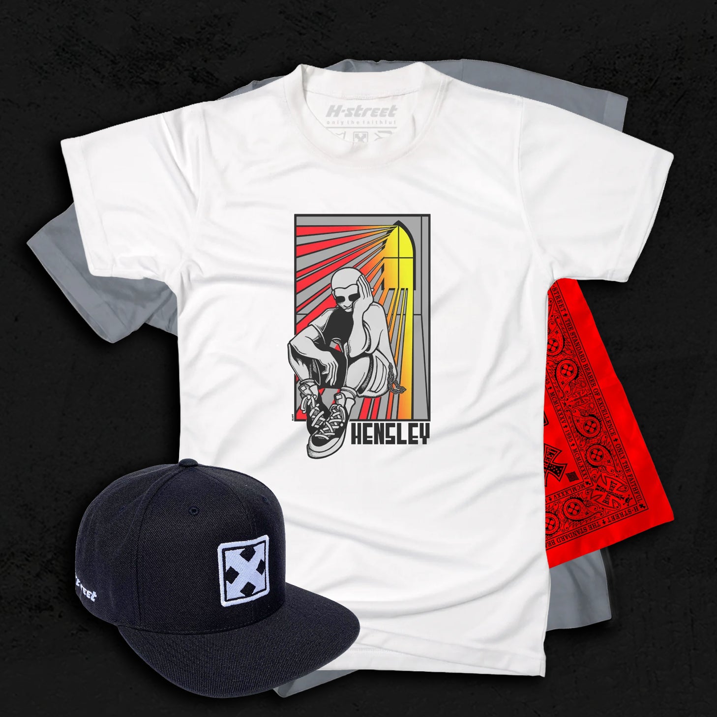 A white graphic tee on top of a grey shirt and a red bandana. A black hat with the H-Street logo is in the front. Everything is on a textured dark grey background.