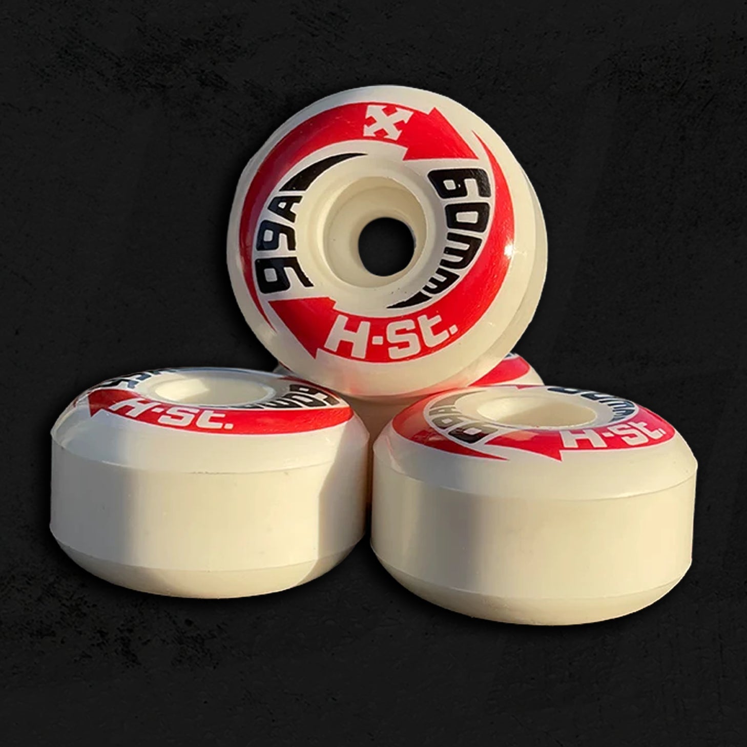 Red and tan skateboard wheels on a textured grey background.