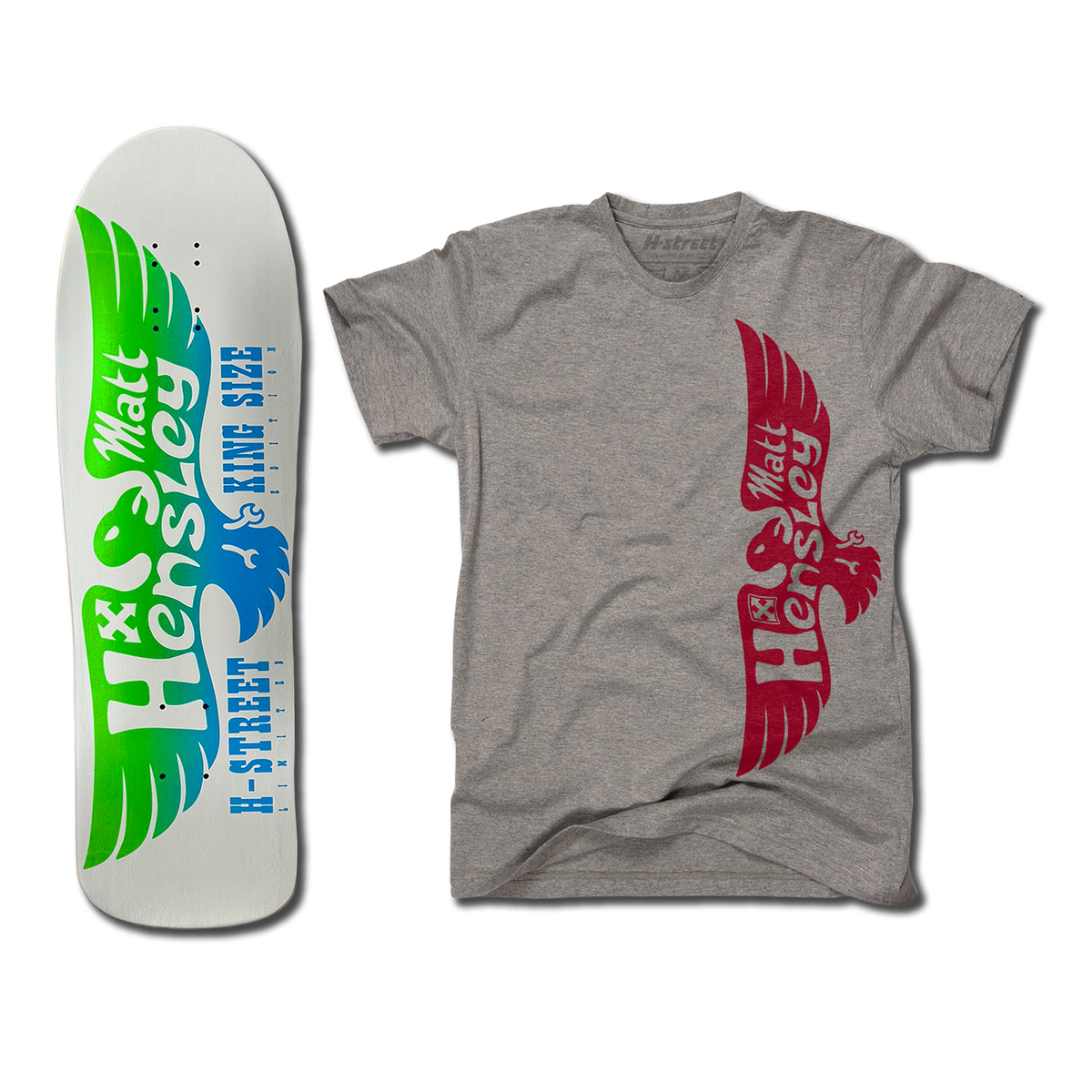The bottom of a Hensley Eagle King Size Skateboard deck. The bottom is white/grey with a green and blue eagle. Next to it is a grey shirt with the red eagle logo on the front.