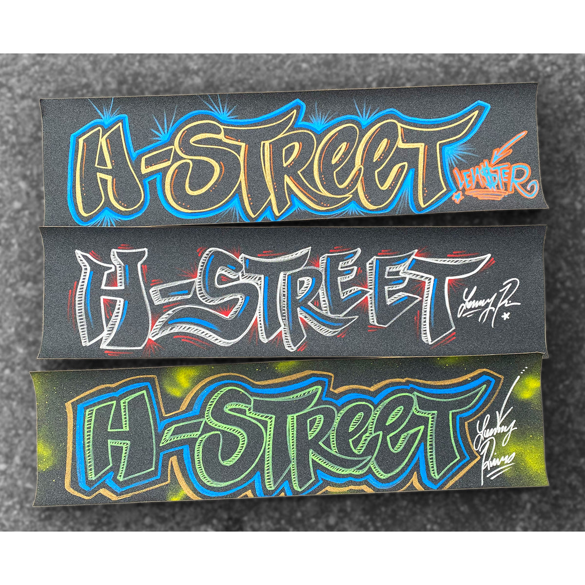 Three pieces of grip tape with the text 'H-STREET' drawn in colorful lettering on a black background with a signature.