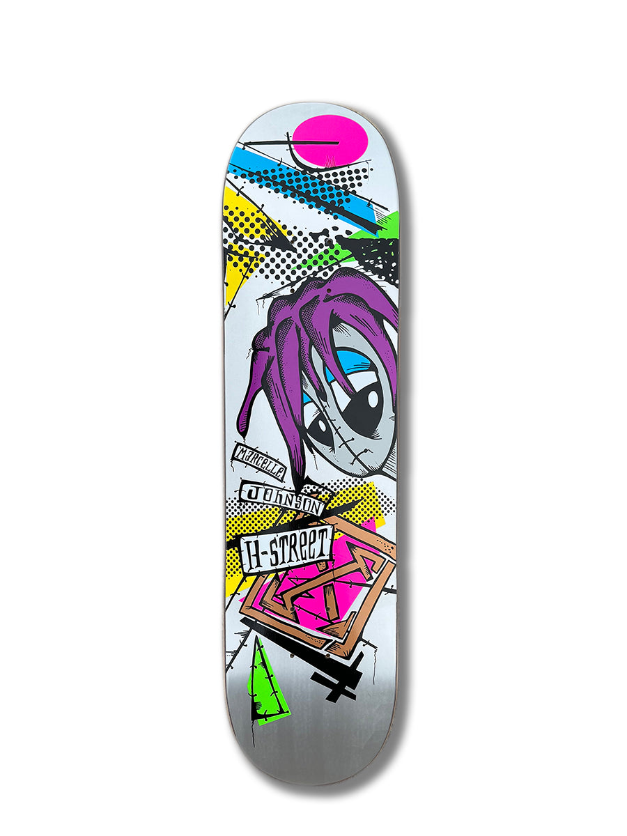 The Woodchuck MARCELLE JOHNSON TRIBUTE GRAPHIC deck showcases vibrant graffiti-style cartoon face art with purple dreadlocks, bold geometric shapes, and H-STREET/J-STREET text on a sleek silver background.