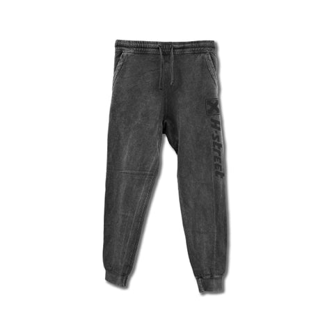 A pair of vintage wash black sweatpants with a drawstring waist, front pockets, and a logo on the side.