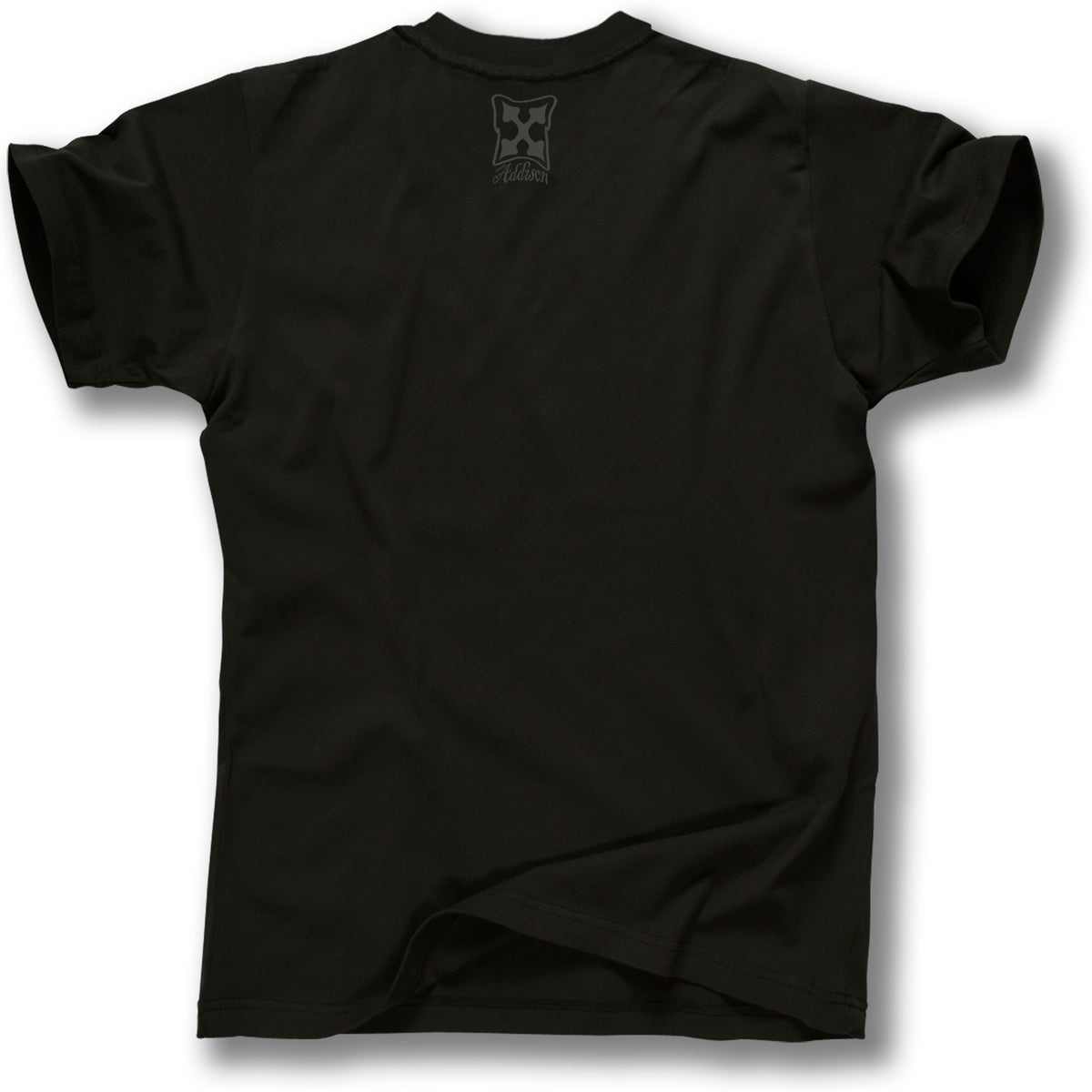 A plain black Minuteman ADDISON TAYLOR DESIGN T-SHIRT is shown from the back, featuring a small light-colored Addison Taylor graphics logo with a cross and text near the neck. It has short sleeves and is slightly wrinkled at the bottom.
