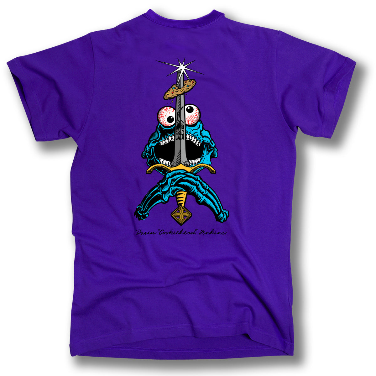 The SWORD AND COOKIE SKULL TEE by Minuteman is a purple shirt with a vibrant cartoon monster wielding a sword and the phrase "Pain Embodied Anchor," capturing bold skate vibes.