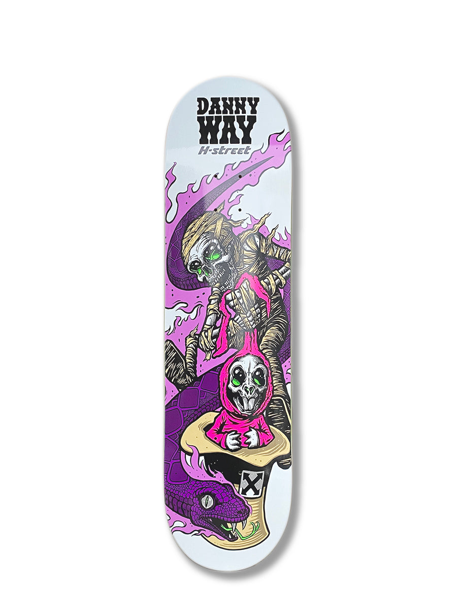The Woodchuck DANNY WAY SERPENT & RABBIT skateboard deck showcases bold artwork of a mummy-like figure and a skeleton in a pink hoodie riding a purple snake, with logos at the top.