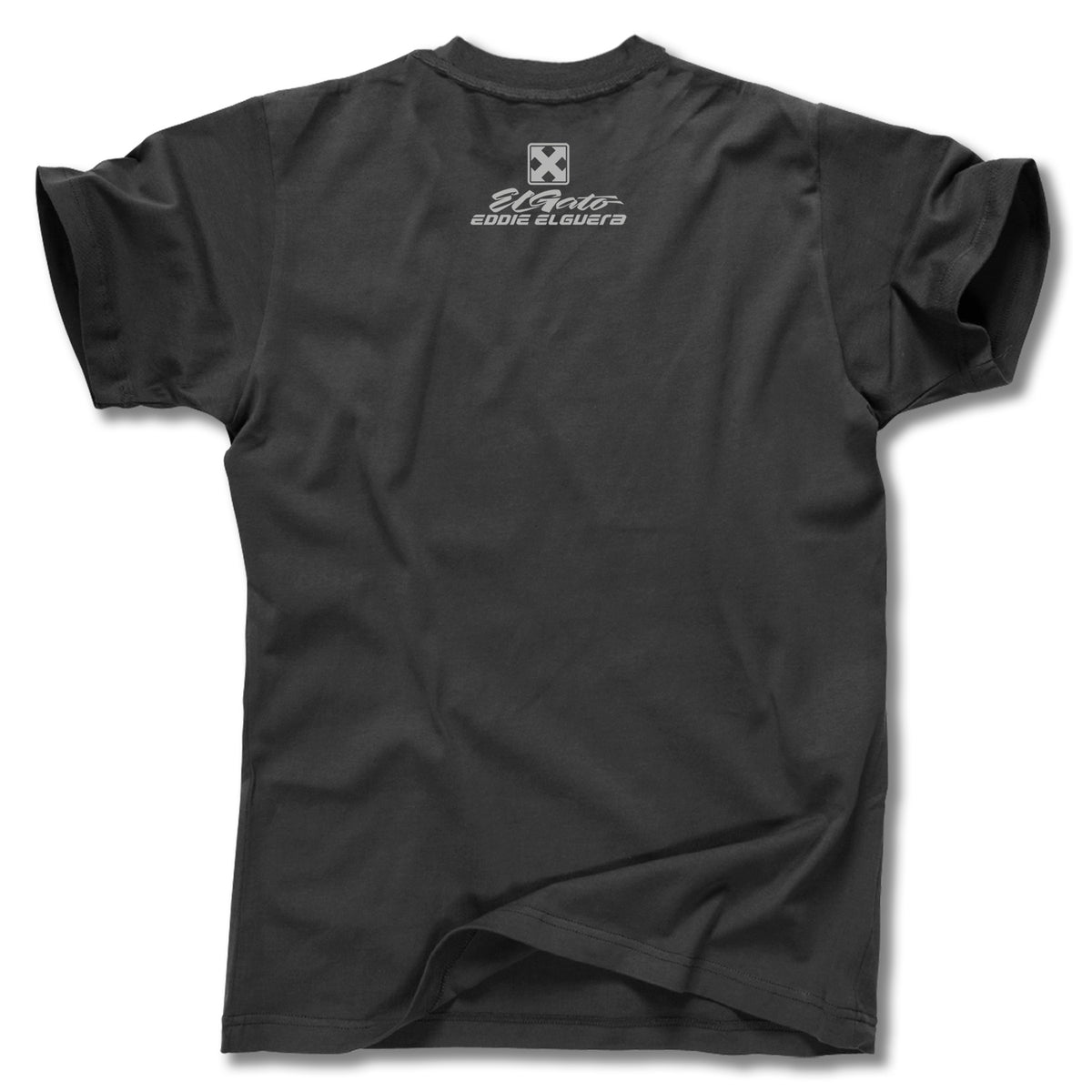 The Minuteman EDDIE ELGUERA EL GATO SCARECROW TEE is a black short-sleeve graphic shirt, shown from the back with a small white logo and "3Moto Eddie Sloper3" text near the neckline, laid flat with a slight bottom fold.