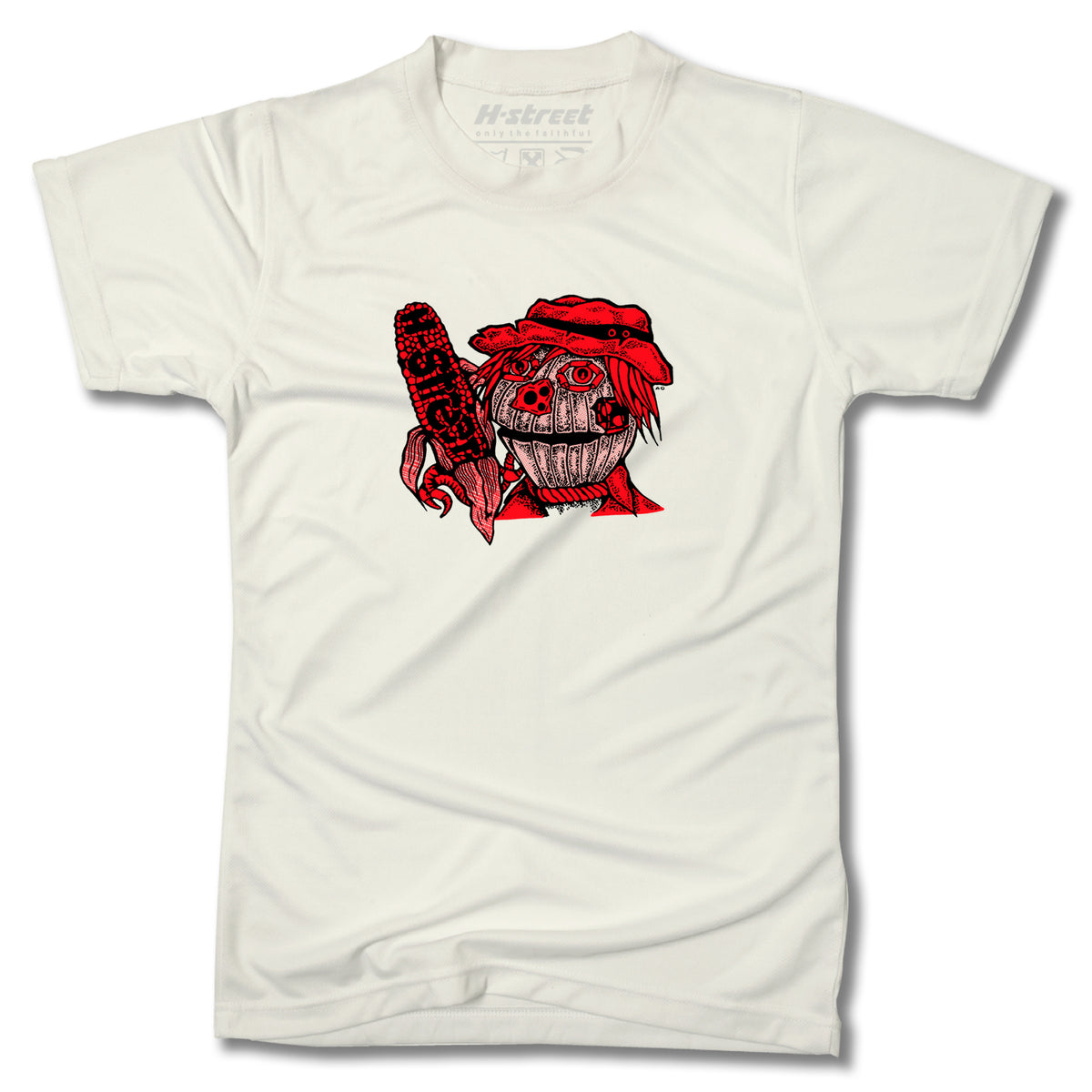 The Minuteman EDDIE ELGUERA EL GATO SCARECROW TEE is a white graphic tee showing a red cartoon creature with a bandana and chainsaw labeled CHAINSAW. Proudly made in the USA.