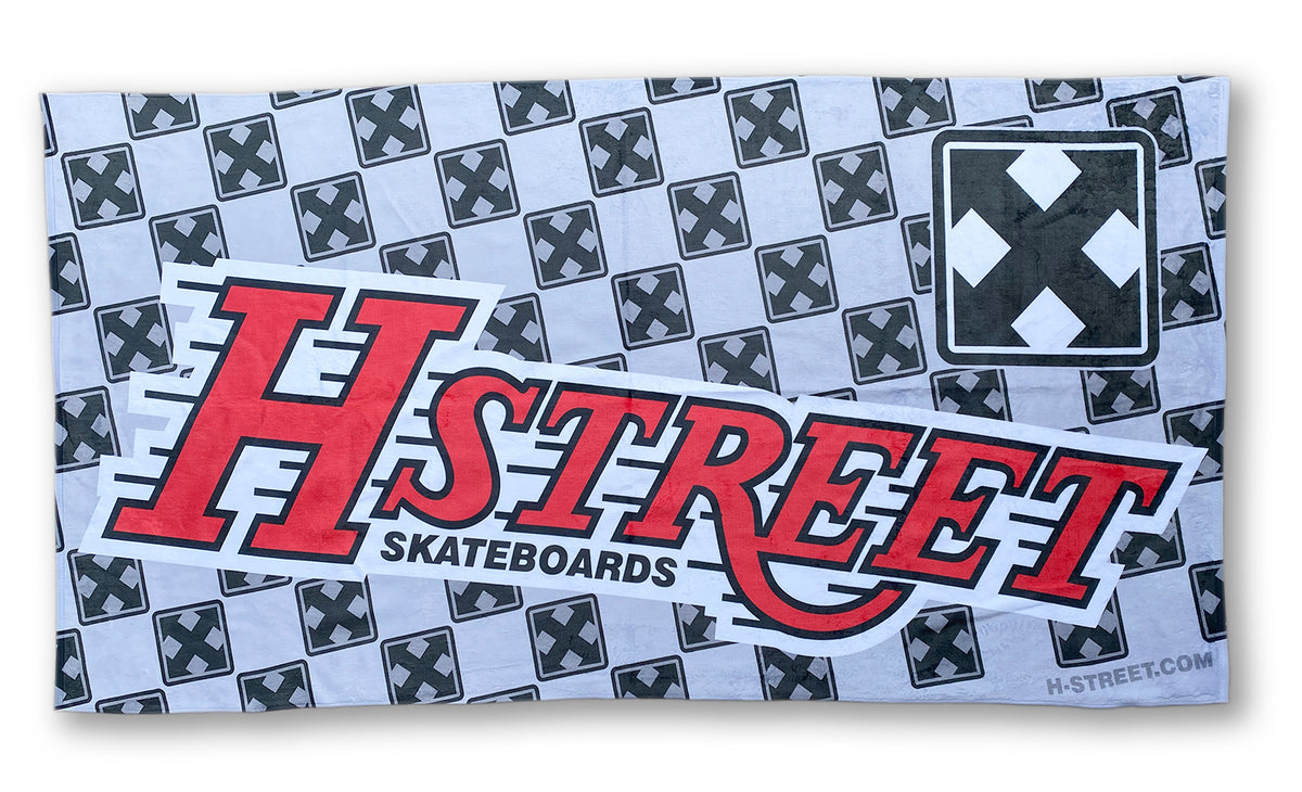 The Edith H-STREET DESIGNER TOWELS feature sublimated graphics: a repeating black X on gray, with “H-STREET SKATEBOARDS” in bold red and black text, plus the H-STREET.COM website in the bottom right corner.