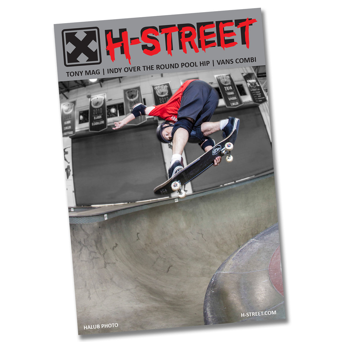 A skateboarder in helmet and pads does an indy grab over a pool hip at an indoor skatepark, with Inkgenda H-STREET 33 STICKER PACK visible on their deck. This image appears on the cover of H-Street magazine.