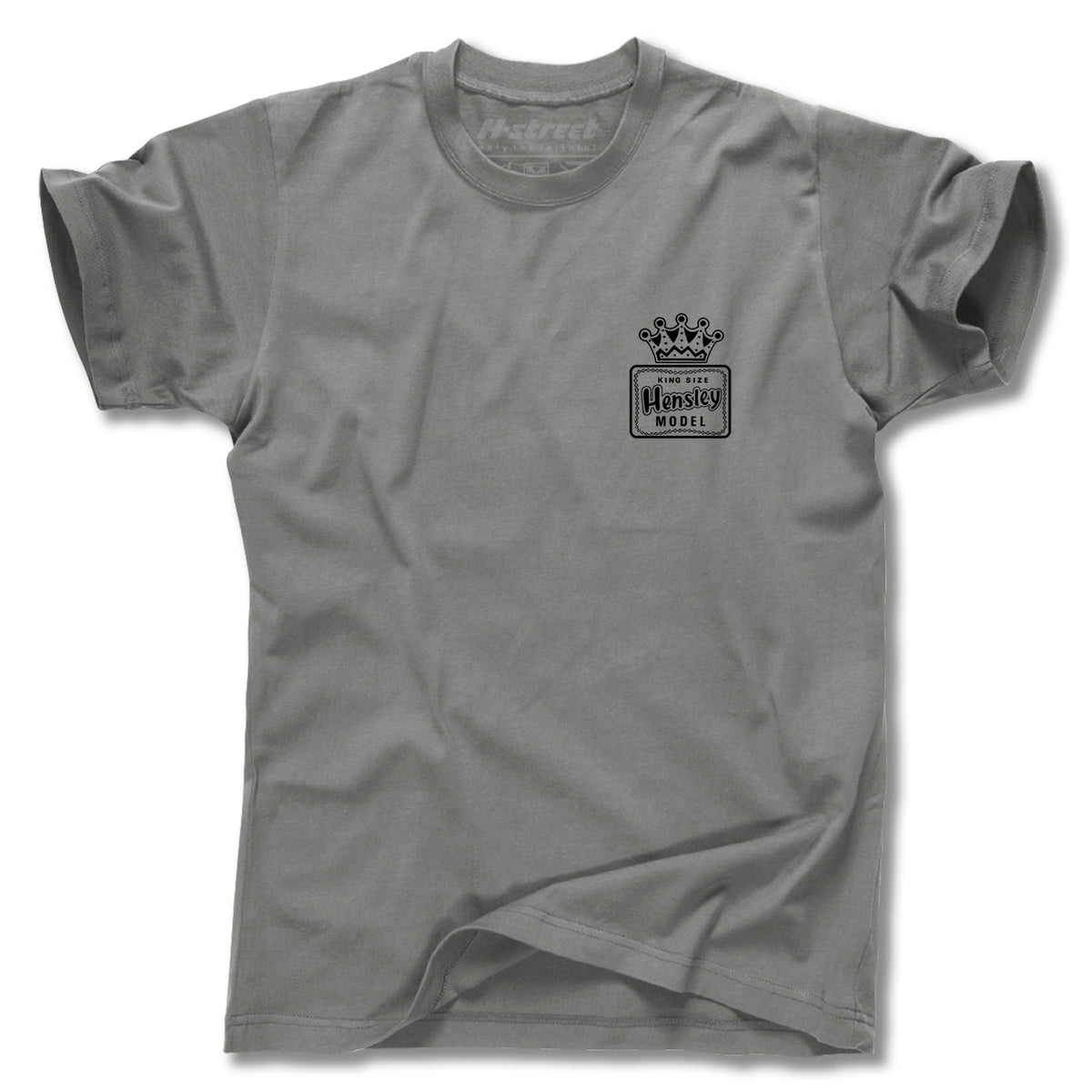 The Minuteman MATT HENSLEY KINGSIZE HORNBLOWER TEE is a gray short-sleeve tee with a small black crown and "Model Hennessy" on the left chest, combining style and comfort. Proudly made in the USA.