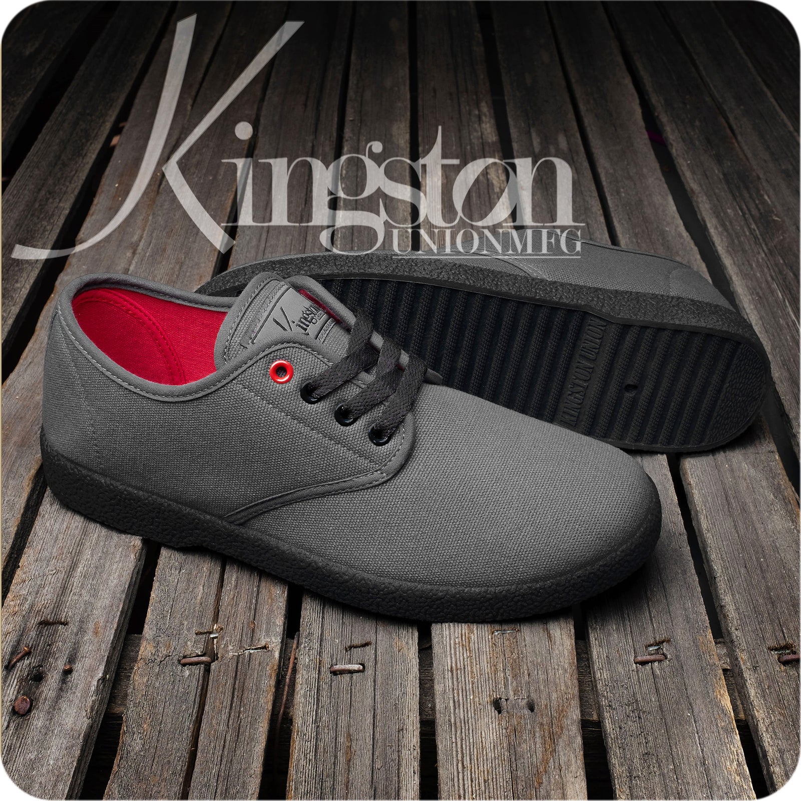 A pair of Kingston Union Mfg WINO HENSLEY COLORWAY shoes with gray uppers, black soles, and red lining are shown on a rustic wood surface, with the Kingston logo in the background.