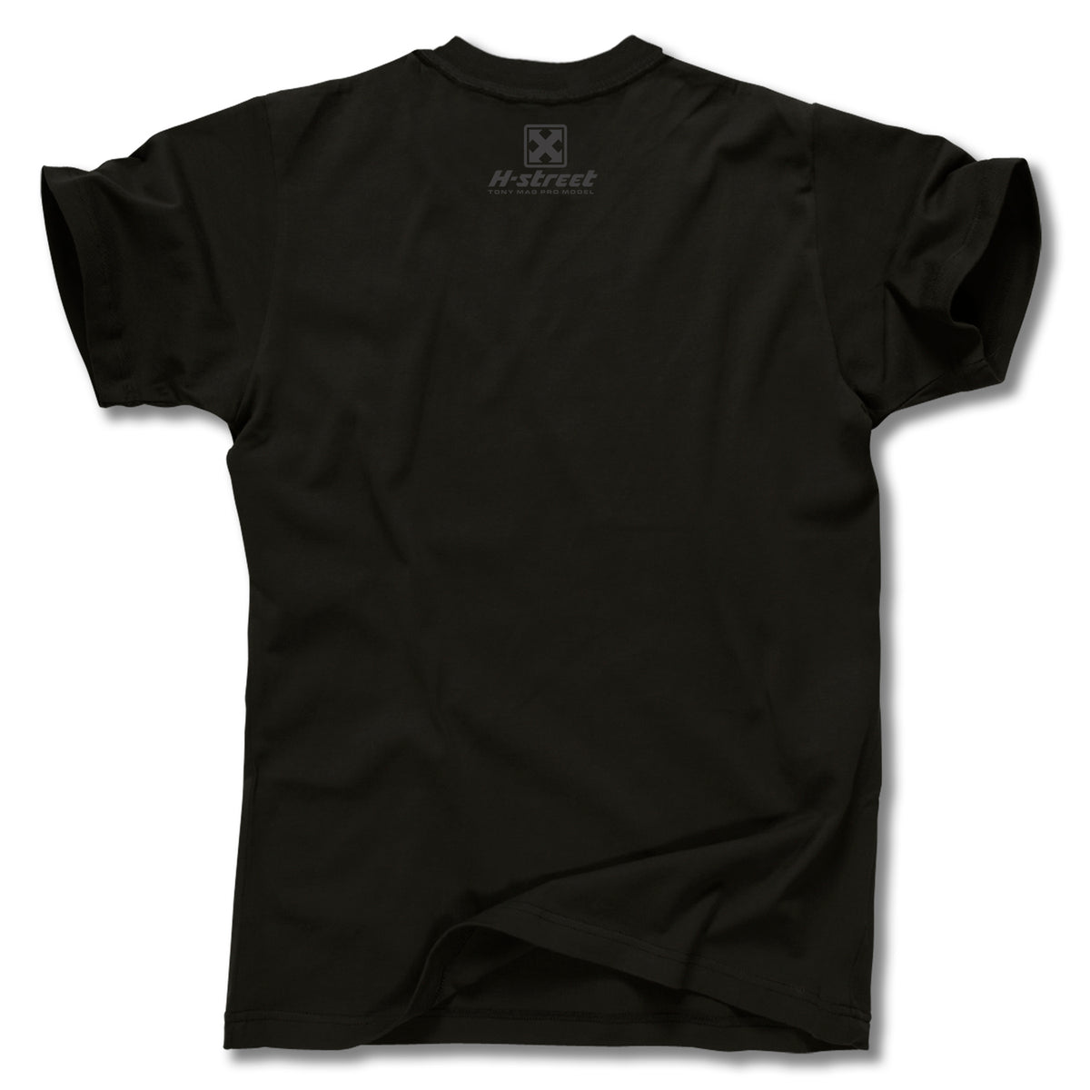 The TONY MAG BORN FREE TEE by Minuteman is a plain black short-sleeve shirt shown from the back, featuring a small H-street logo and emblem near the upper neckline. Part of a skateboard art collaboration, with slight creasing at the bottom.