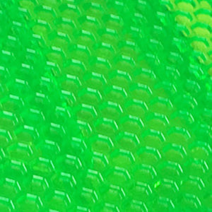 Close-up of a bright green, honeycomb-patterned textured surface from the Mindtwister USA ZIPPY FLYER COMPLETE skateboard, with light highlighting its hexagonal shapes.