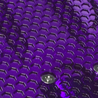 Close-up of a textured, shiny purple surface with repeating hexagons and metal screws, evoking the vibrant ZIPPY FLYER COMPLETE by Mindtwister USA—ideal for sidewalk surfing enthusiasts.